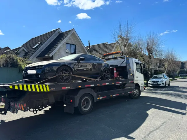 Auto deportivo amarrado con eslingas sobre la grúa