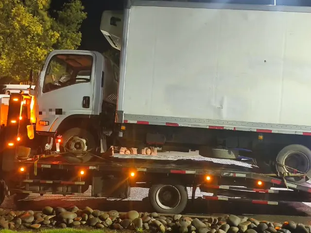 Camión 3/4 cargado sobre grúa plataforma de noche