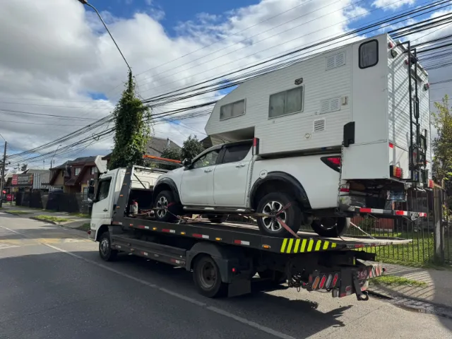 Camioneta con camper sobre grúa plataforma
